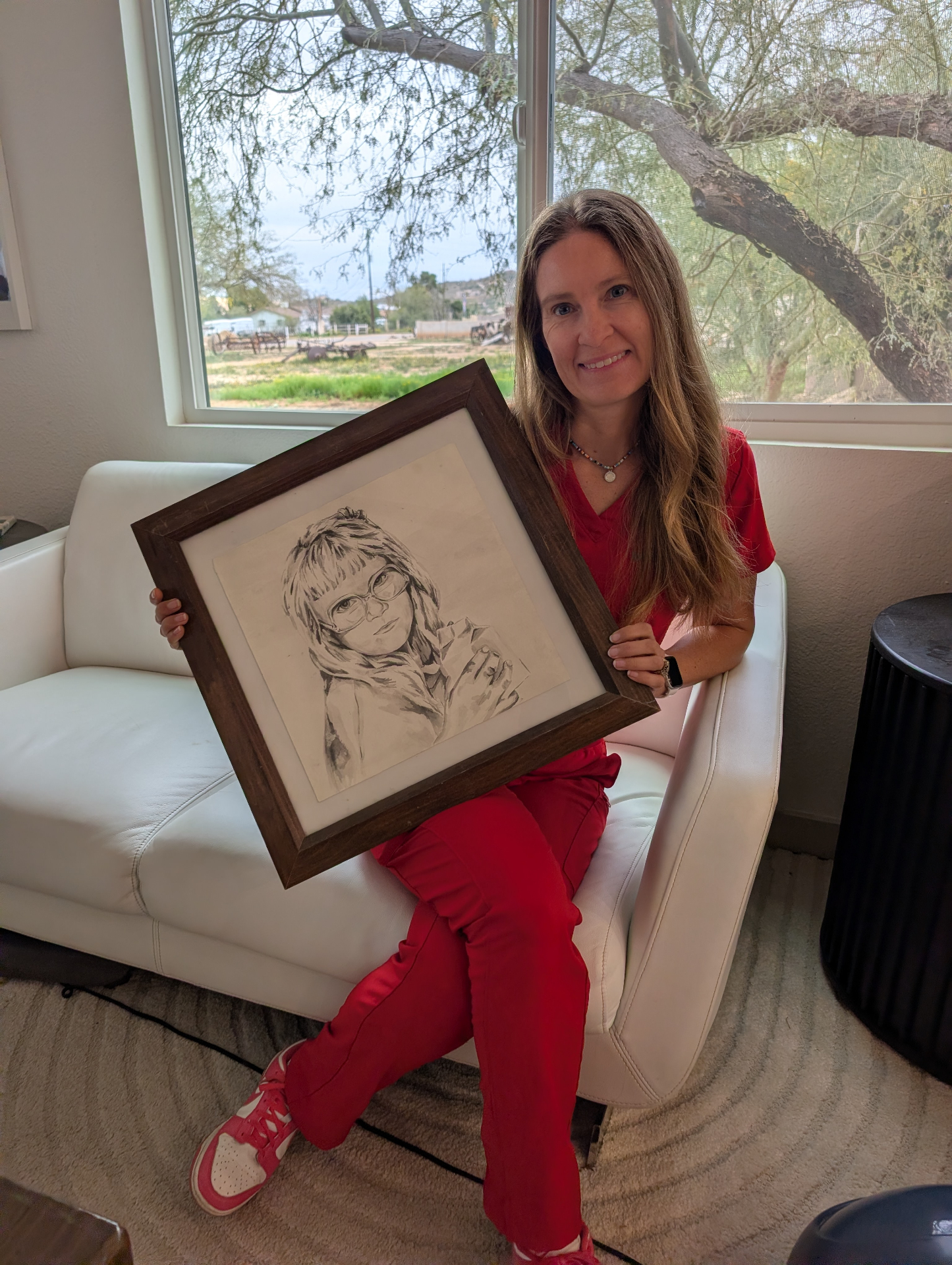 Lindsey Forstie, FNP holding the framed childhood drawing that inspired the Carefree Allergy logo